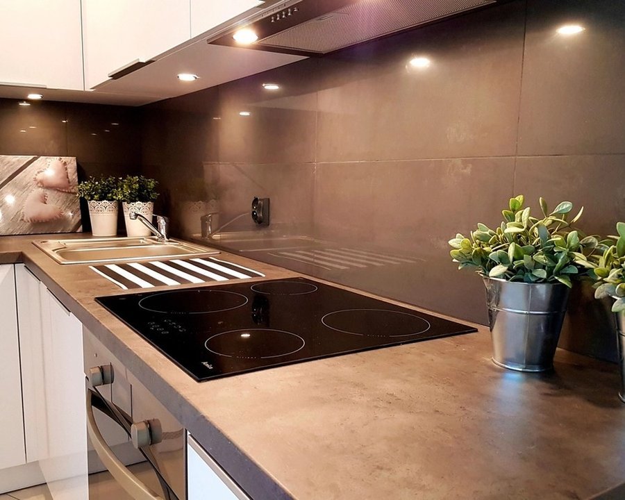 Cocina integral terminada con cubierta de madera, alacenas blancas y salpicadero oscuro