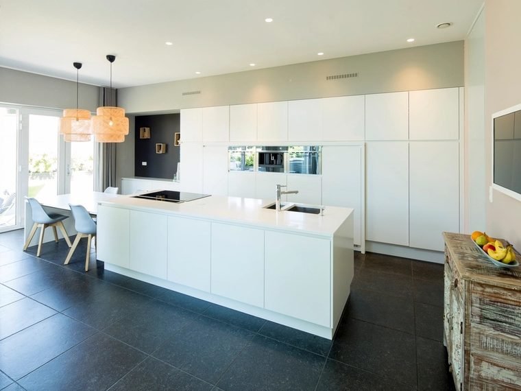 Cocina terminada con isla blanca y piso de porcelanato oscuro