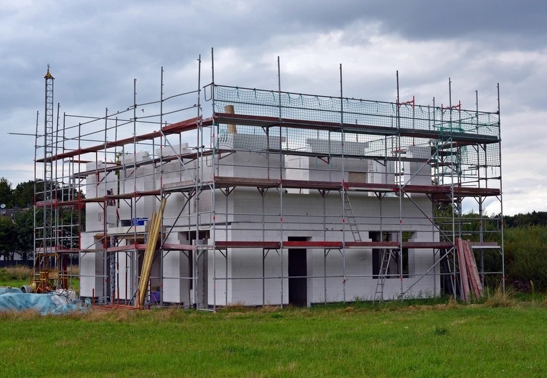 Vivienda en construcción con andamios montados en toda la fachada